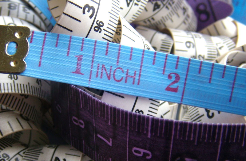 A jumble of blue, white and purple tape measures