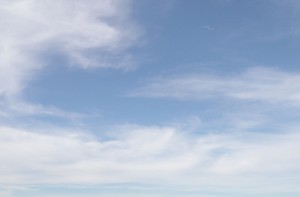 Swirly white clouds against a blue sky